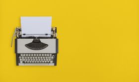 typewriter on yellow background