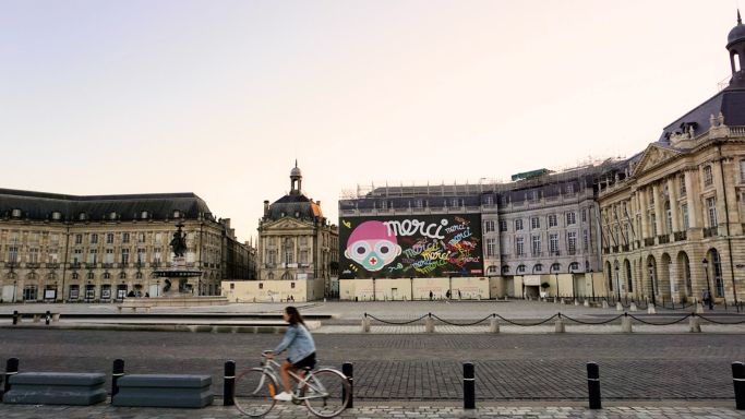 A woman bikes near Bordeaux's deserted Place de la Bourse during France’s first Covid-19 lockdown. Photo author's own