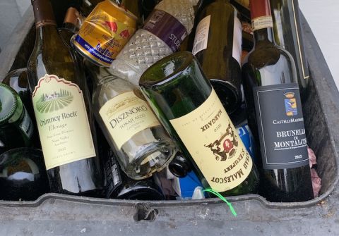 Empty wine bottles in a recycling bin