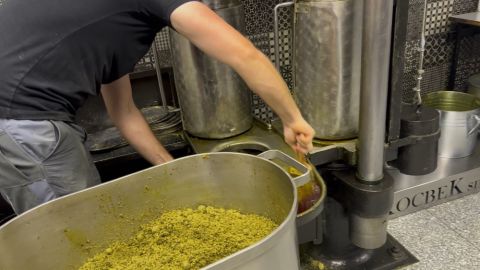 Filling the press with roasted, crushed seeds