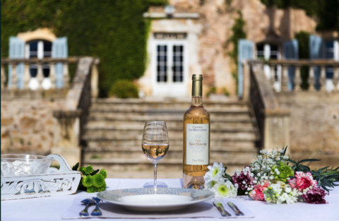 Bottle of Mesclances Honorat Rosé in front of the chateau