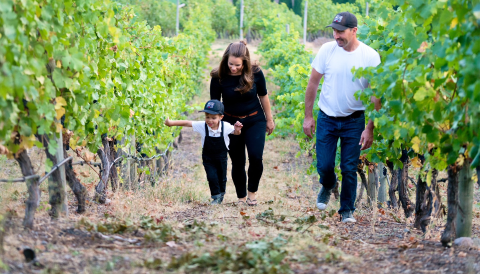Joanna and James Schlosser, and their son Hugh walking the family vineyards.