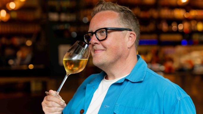 Olly Smith sniffing a glass of white wine